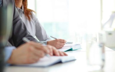Working at conference Hand of businesswoman with ballpoint over open notebook at convention